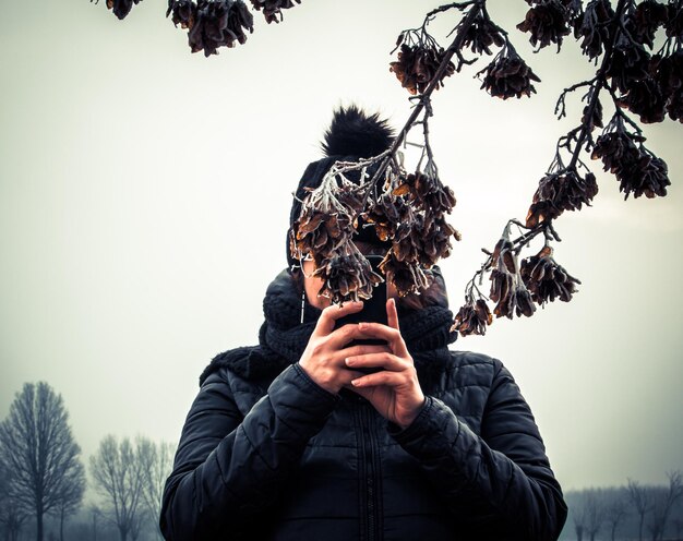 Zdjęcie portret osoby fotografującej na tle nieba