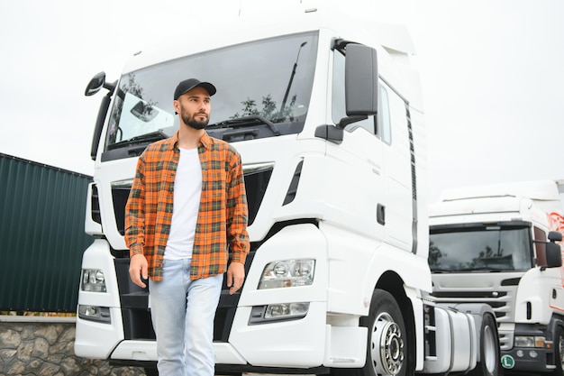 Zdjęcie portret pewnego siebie kierowcy ciężarówki na parkingu. kopiuj miejsce