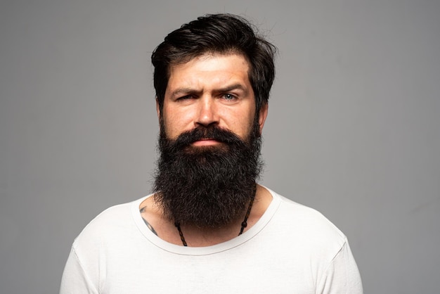 Portret pewny siebie poważny mężczyzna ma brodę i wąsy, wygląda poważnie, na białym tle. Modele facet hipster w studio. Biznesmen myślenia z wyrażeniem patrząc. Przystojny męski model, zbliżenie twarzy.