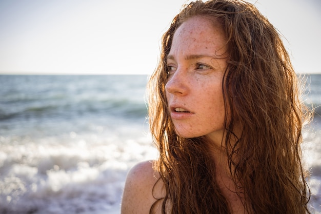 Zdjęcie portret piegowata piękna kobieta na zmierzch plaży