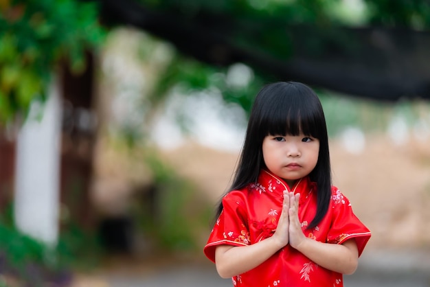 Portret piękna azjatycka dziewczynka w sukience CheongsamTajlandia ludzieSzczęśliwego chińskiego nowego roku koncepcjaSzczęśliwa mała azjatycka dziewczynka w chińskim tradycyjnym stroju