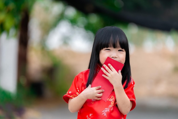 Portret Piękna Azjatycka Dziewczynka W Sukience Cheongsamtajlandia Ludzieszczęśliwego Chińskiego Nowego Roku Koncepcjaszczęśliwa Mała Azjatycka Dziewczynka W Chińskim Tradycyjnym Stroju