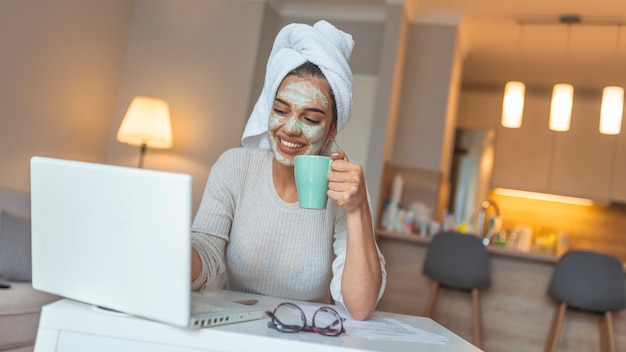 Zdjęcie portret piękna kobieta z twarzową maską bierze kawę w domu