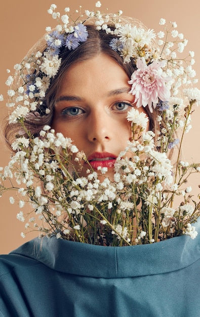 Portret piękna kobiety lub zbliżenie kwiatów do makijażu kosmetyków naturalnych lub mody w studio na wiosnę Model korony kwiatowej rośliny do twarzy lub naturalna estetyka do kosmetycznych ubrań organicznych lub sztuki twarzy