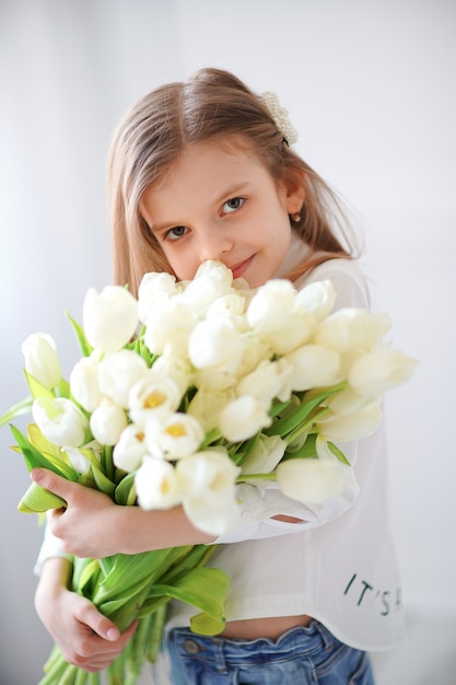 Portret piękna ładna dziewczyna z białych kwiatów tulipanami