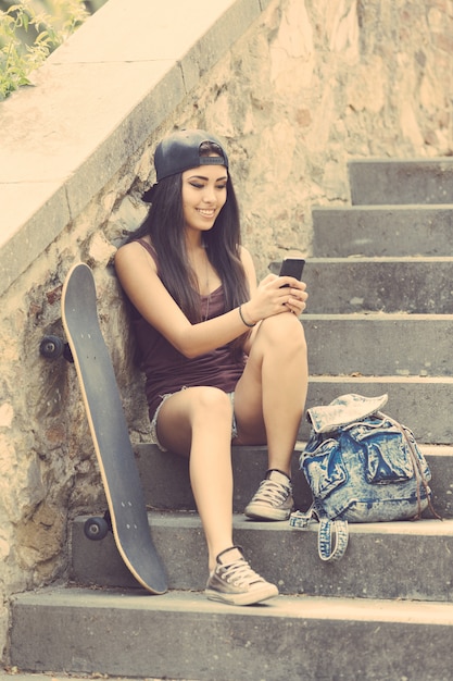 Portret piękna łyżwiarki dziewczyna patrzeje mądrze telefon