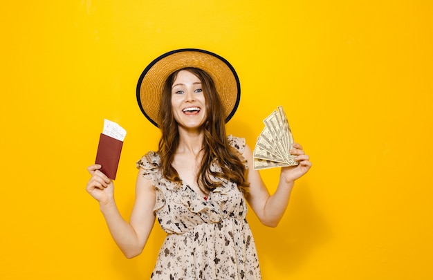 Portret piękna szczęśliwa brunetki dziewczyny mienia pieniądze banknoty podróżuje bilety i paszport