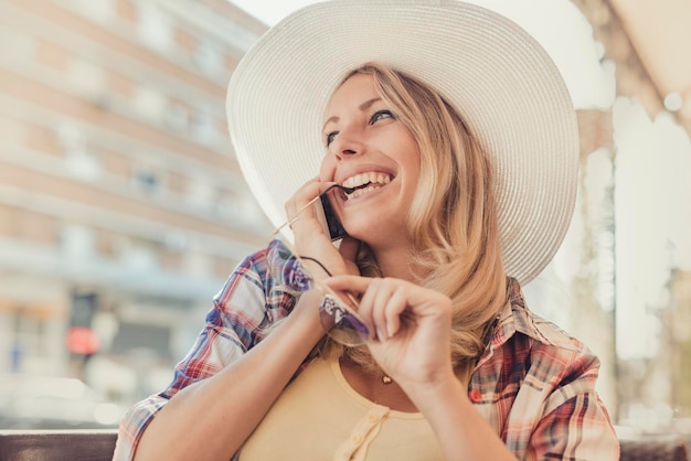 Portret piękna uśmiechnięta kobieta używa telefon komórkowego outdoors