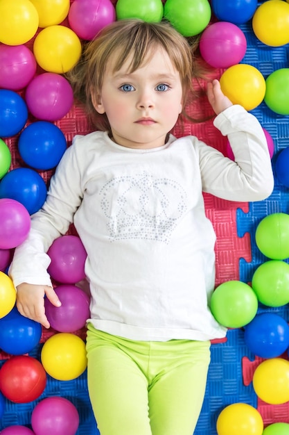 Portret Pięknego Niebieskookiego Dziecka Leżącego W Kolorowych Kulkach, Widok Z Góry