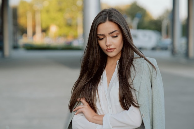 Portret pięknej atrakcyjnej seksownej kobiety brunetka z długimi włosami i ciemnymi oczami patrzy w dół