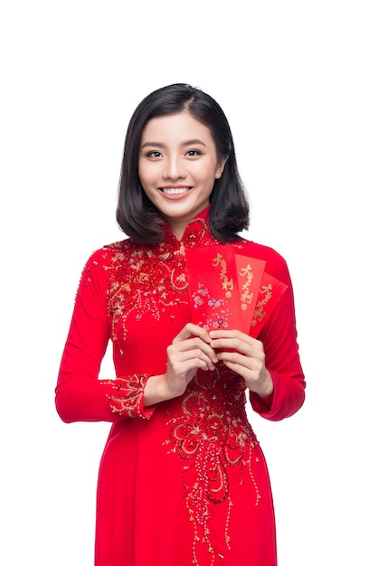 Portret pięknej azjatyckiej kobiety na tradycyjnym stroju festiwalowym Ao Dai trzyma czerwoną kieszeń - szczęśliwe pieniądze. Te wakacje. Nowy Rok Księżycowy.
