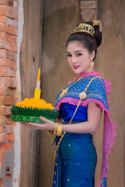 Portret pięknej azjatyckiej kobiety w tajskim stroju tradycyjnej modlitwy trzymaj kratong, aby dołączyć do festiwalu loy kratong w tajlandii