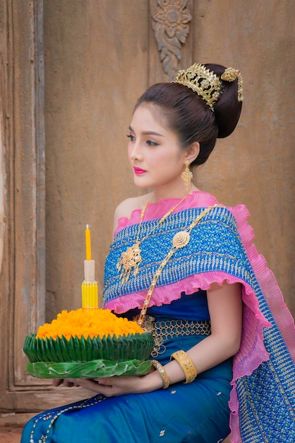 Portret pięknej azjatyckiej kobiety w tajskim stroju tradycyjnej modlitwy trzymaj kratong, aby dołączyć do festiwalu loy kratong w tajlandii