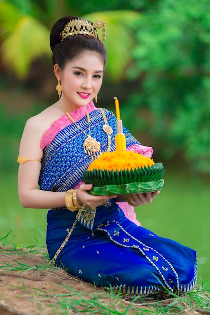 Portret pięknej azjatyckiej kobiety w tajskim stroju tradycyjnej modlitwy trzymaj kratong, aby dołączyć do festiwalu loy kratong w tajlandii