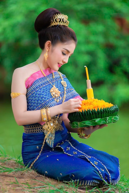 Portret pięknej azjatyckiej kobiety w tajskim stroju tradycyjnej modlitwy trzymaj kratong, aby dołączyć do festiwalu loy kratong w tajlandii