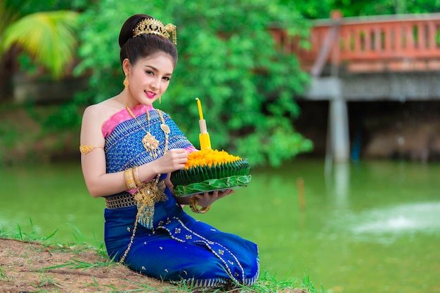 Portret pięknej azjatyckiej kobiety w tajskim stroju tradycyjnej modlitwy trzymaj kratong, aby dołączyć do festiwalu loy kratong w tajlandii