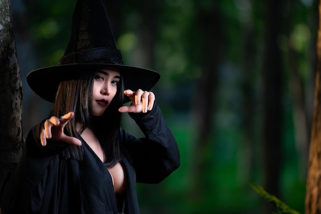Portret pięknej azjatyckiej seksownej kobiety nosi czarny kostium czarownicy z koncepcją festiwalu miotłyHalloween