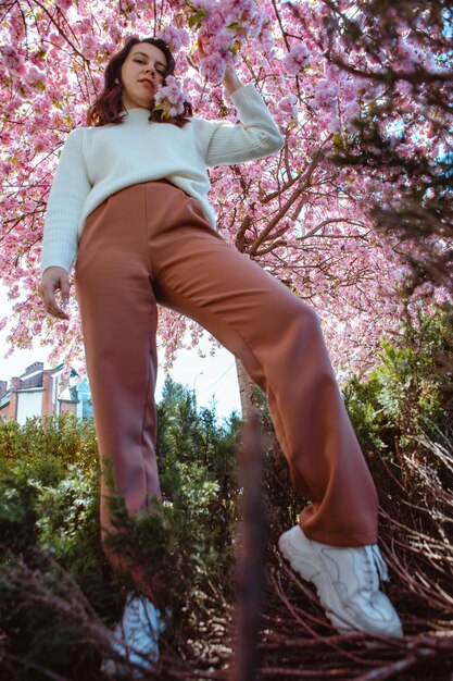 Portret pięknej białej kobiety z kwitnącymi wiśniami sakura