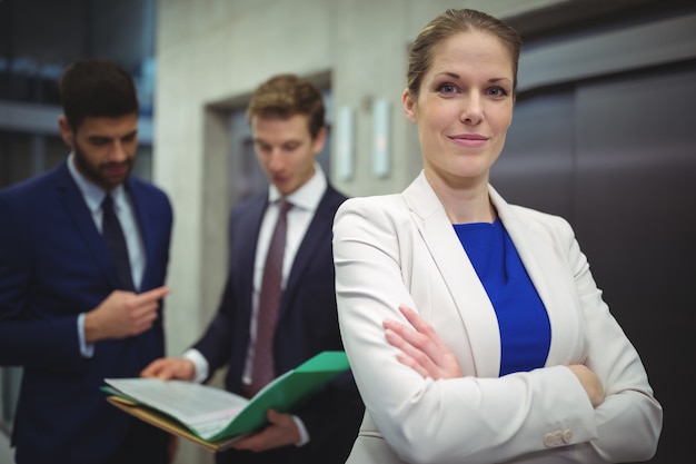 Portret pięknej bizneswoman stojącej z rękami skrzyżowanymi