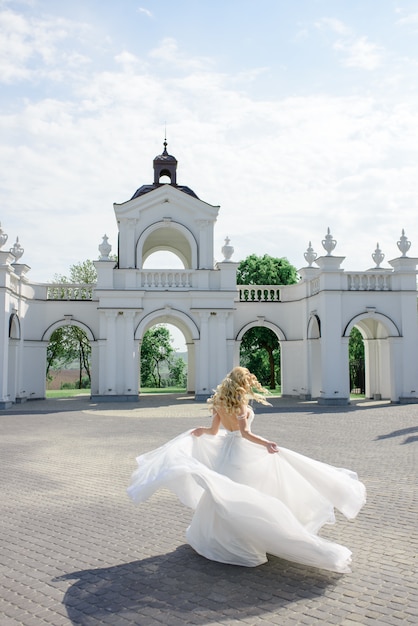 Portret pięknej blondynki panny młodej. Kobieta wiruje w białej sukni.