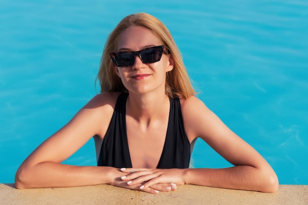Portret pięknej blondynki w odkrytym basenie