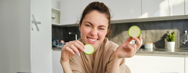 Zdjęcie portret pięknej brunetki gotującej w kuchni, pozującej w szlafroku w domu