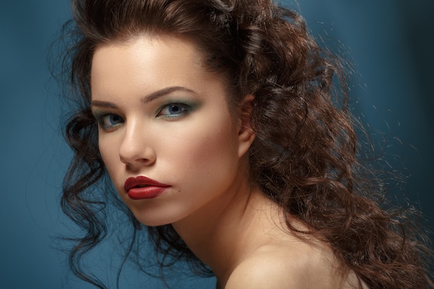 Portret pięknej brunetki z falującymi włosami i jasnym makijażem