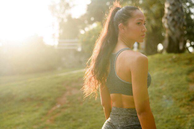 Portret pięknej dopasowanej kobiety noszącej odzież sportową w parku Koncepcja zdrowia i sportu