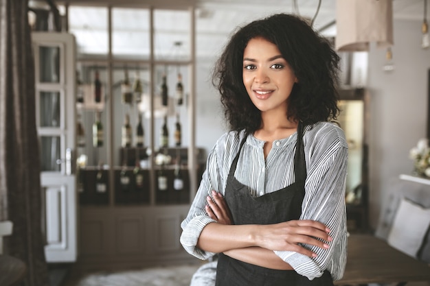 Portret pięknej dziewczyny African American na sobie koszulę i fartuch w restauracji