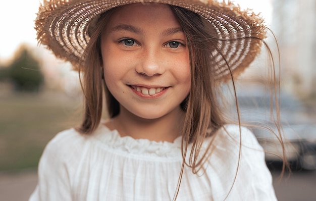 Portret pięknej dziewczyny z długimi włosami i piegami na zewnątrz w lecie