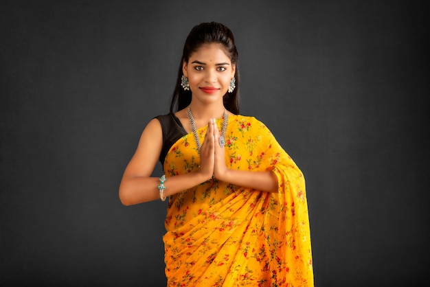 Portret pięknej indyjskiej dziewczyny w powitalnej pozie do rąk Namaste Hinduska w tradycyjnym sari