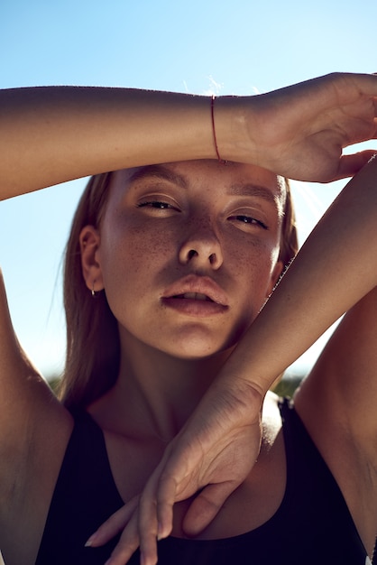 Portret Pięknej Kobiety Rasy Kaukaskiej Opalony Model O Ciemnych Długich Włosach W Paski Strój Kąpielowy Leżącego Na Plaży Latem Z Białym Piaskiem. Widok Z Góry