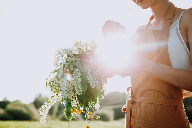 Portret pięknej kobiety robi wieniec z kwiatów mlecze na kwitnącym polu Letni styl życia