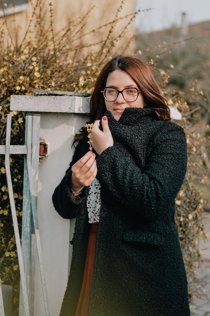 Zdjęcie portret pięknej kobiety stojącej przy ścianie w zimie