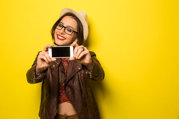 Portret pięknej kobiety uśmiechnięte sukcesy robi selfie na żółtej ścianie