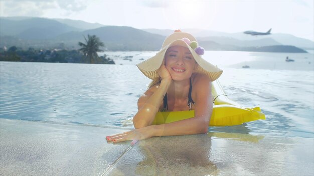 Zdjęcie portret pięknej kobiety w basenie w tropikalnym kurorcie na świeżym powietrzu