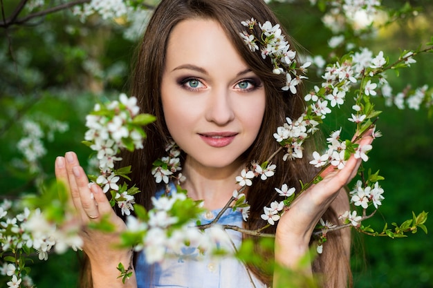 Zdjęcie portret pięknej kobiety w kwitnących wiśni ogród