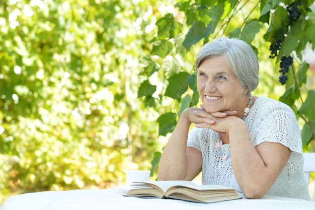 Portret pięknej kobiety w średnim wieku na zewnątrz przy stole