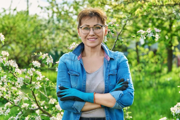 Portret pięknej kobiety w średnim wieku w kwitnącym wiosennym ogrodzie