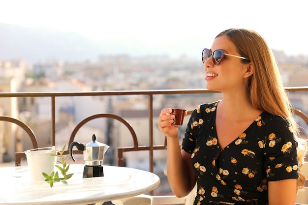 Portret Pięknej Kobiety Z Okulary Siedzi Na Tarasie, Picia Włoskiej Kawy O Zachodzie Słońca