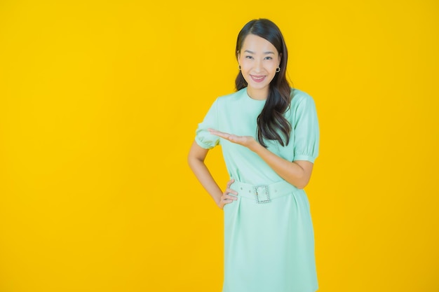 Portret pięknej młodej azjatyckiej kobiety uśmiech z akcją na kolorowym tle