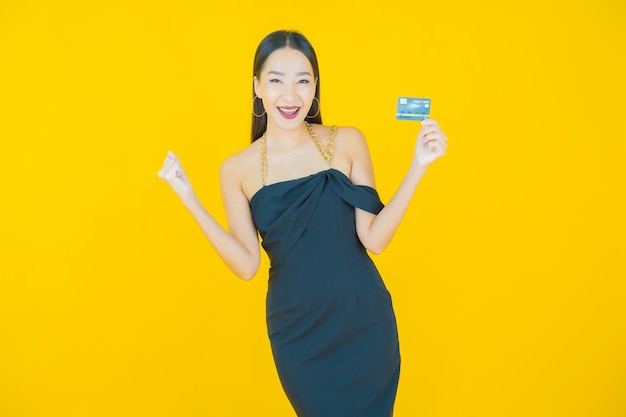 Portret pięknej młodej azjatyckiej kobiety uśmiech z kartą kredytową