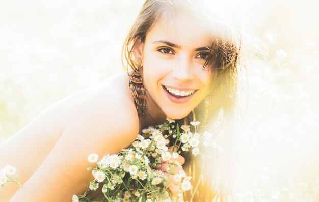 Portret pięknej młodej dziewczyny na wiosnę z polnych kwiatów Szczęśliwa letnia twarz młodej kobiety w zielonym polu przyrody