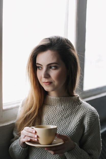 Portret pięknej młodej dziewczyny picia kawy