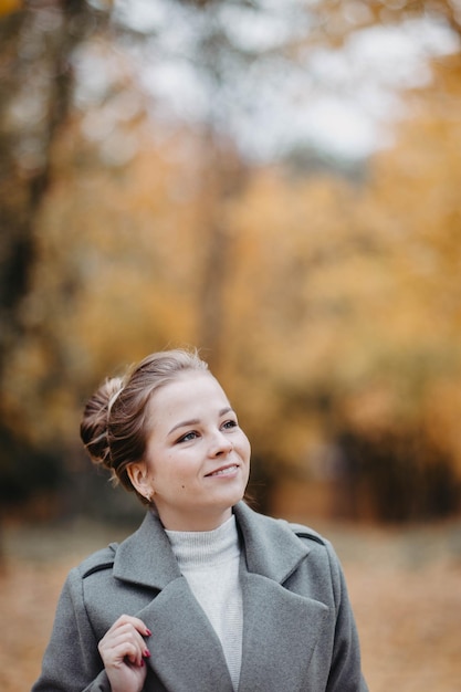 portret pięknej młodej dziewczyny w jesiennym parku w płaszczu