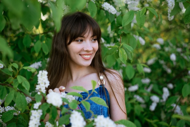 Portret pięknej młodej kobiety na tle kwitnącego krzewu Czeremcha