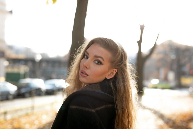 Zdjęcie portret pięknej młodej kobiety stojącej na zewnątrz