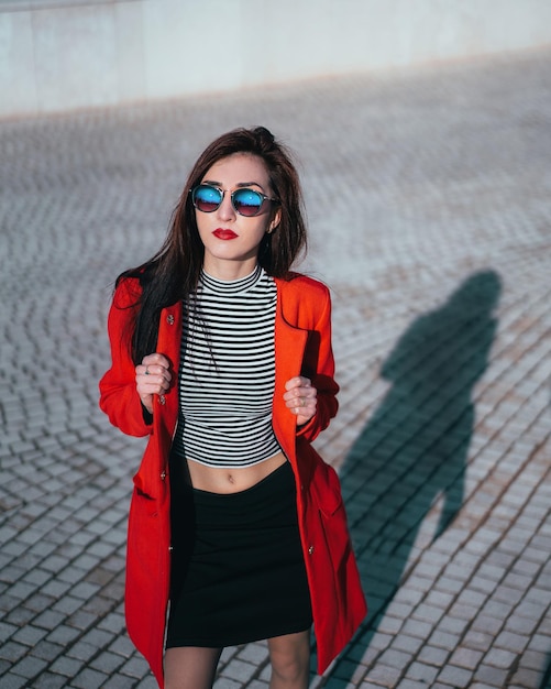 Portret pięknej młodej kobiety stojącej przy ścianie