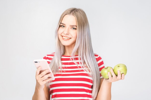 Portret pięknej młodej kobiety trzymającej jabłko i telefon