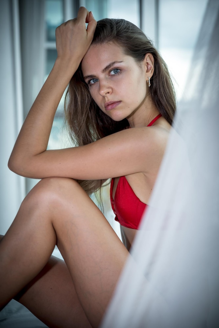 Zdjęcie portret pięknej młodej kobiety w bikini siedzącej w domu